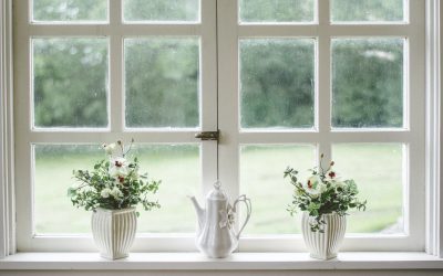 white teapot and tow flower vases on windowpane